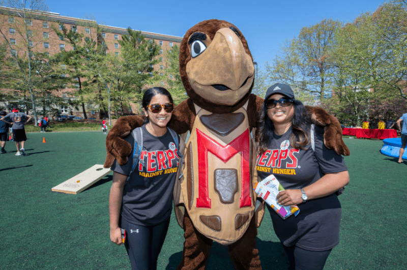 two students pose with testudo